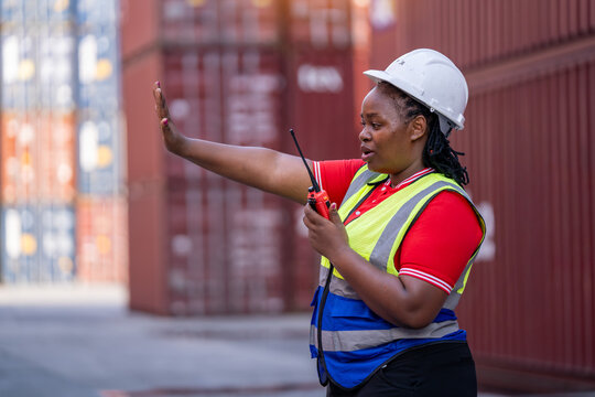 Warehouse safety officer directing operations shipping yard action shot industrial environment close-up perspective leadership role