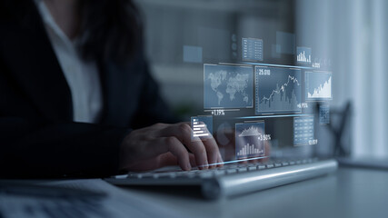 A focused business professional engages in financial data analysis using digital charts overlaid on a keyboard, showcasing a modern workspace environment. Scalp