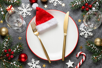 Festive Christmas Dinner Table Adorned with Elegant Decorations, a Charming Santa Hat, and Seasonal Ornaments, Ready for a Joyful Holiday Celebration