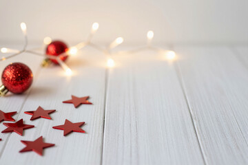 Festive red Christmas baubles and stars on white wood with soft fairy lights, creating a warm holiday atmosphere, perfect for seasonal celebrations