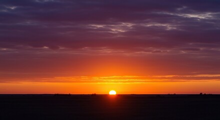 A breathtaking, wide vista showcasing the sky ablaze with intense orange, purple, crimson, and golden hues as the giant sun dips below the distant horizon line ,majestic ,red ,horizon