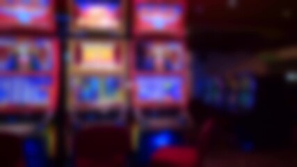 Red illuminated slot machines with colorful graphics and bright LED screens creating a vibrant casino gaming atmosphere. - Powered by Adobe