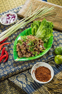Thai larb salad with minced meat, herbs, onions, and spices, served with lettuce and chili.