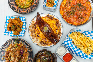 Fusion food spread with grilled eel, pizza, fries, chicken, pasta, and colorful garnishes.