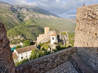 ancient stone fortress perched above emerald reservoir with sweeping hillside views and heritage