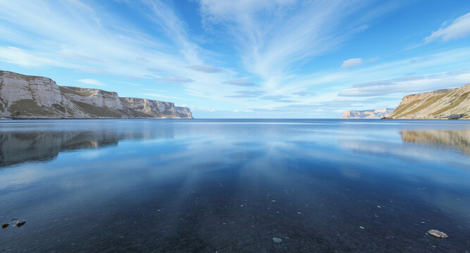Serene coastal landscape with calm waters reflecting the sky and cliffs, a peaceful escape to nature's beauty, ideal for travel and relaxation themes