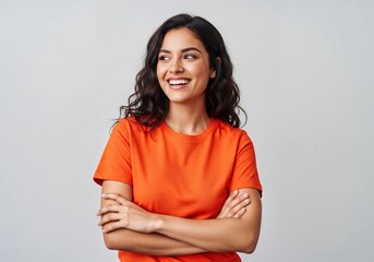 Obraz premium Happy young adult woman in orange t-shirt smiling looking away with crossed arms