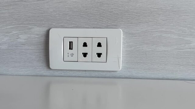 a hand plugging a power cord into an outlet, showing a clean modern setting with clear motion, steady lighting, and a simple action emphasizing safety, connection, and energy use