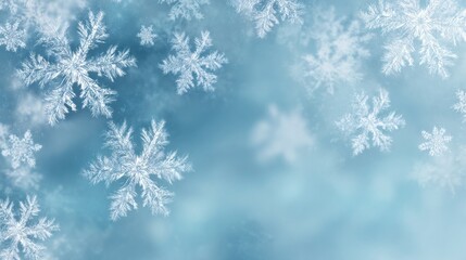 Delicate snowflakes gently fall against a soft blue background, creating a serene winter atmosphere.