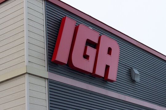 Canada, Quebec, 19 November 2025 : Red letters on grocery store building exterior under bright cloudy sky