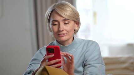 Happy beautiful middle aged woman texting messages online on smartphone, smiling sharing jokes and funny videos. Positive female spending free time with phone, chatting with friends in social media.