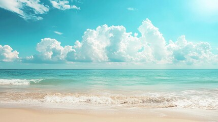 Fototapeta premium A serene beach scene with a clear blue sky and white clouds, a calm ocean, and a sandy shore.