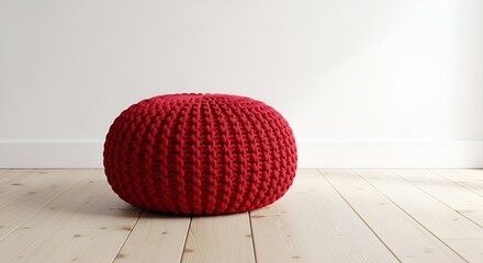 Vibrant Red Knitted Pouf on Wooden Floor Against a Clean White Wall Background