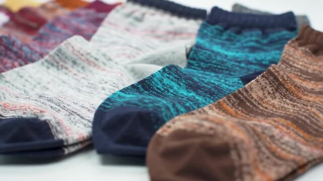Several socks in various textures and colors are laid out, with a focus on their patterns. The angle shows a detail view