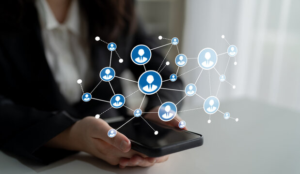 A person interacts with a smartphone while visualizing digital connections and networks in a modern office. This image symbolizes community and collaboration in technology. Tessel - Powered by Adobe