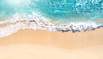 Aerial view of a sandy beach as turquoise waves crash onto the shore, clear day
