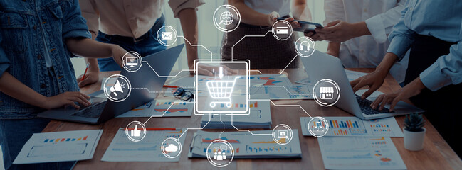 A dynamic group of professionals engages in brainstorming sessions about e-commerce strategies, utilizing digital tools and analyzing data charts in a contemporary workspace. Trope