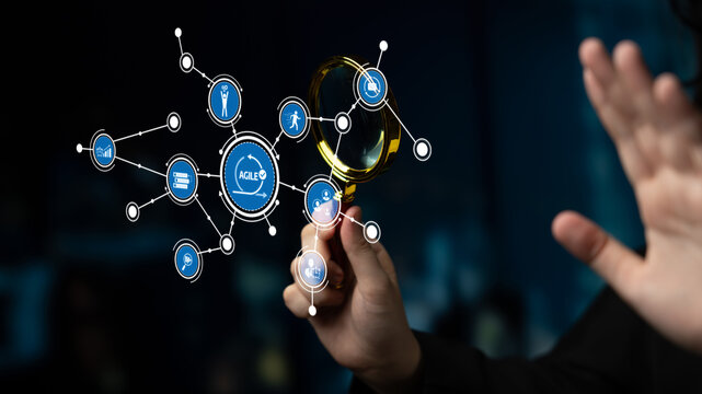 A close-up view of a hand holding a magnifying glass, highlighting various digital icons representing data and information technology in a blurred dark background. Tessel