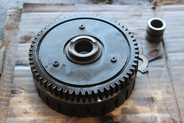 A circular metal gear assembly with detailed teeth and central bearing