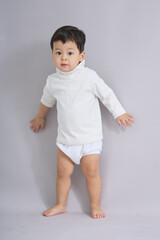 The child stands calmly with arms relaxed.