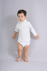 The child stands with one arm extended outward.