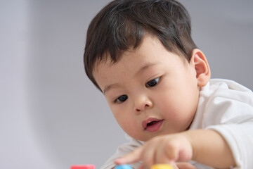 Close-up of the child lying down, face near the toy cars with a gentle expression.