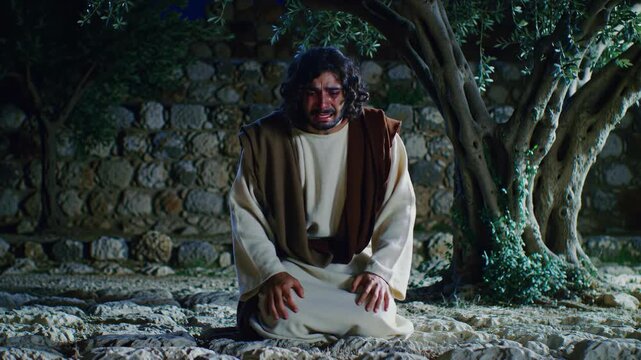 Jesus Christ praying in the Garden of Gethsemane at night, a solemn moment of spiritual reflection and devotion.