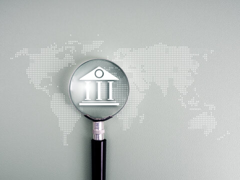 Magnifying glass focusing on bank icon over world map, representing global online banking, currency exchange, digital finance, fintech, and international money transfer in the digital economy. - Powered by Adobe