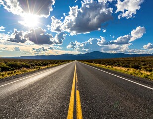 Road stretches into distance under sunlit cloudy sky