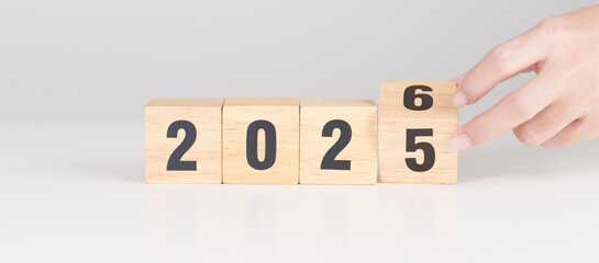 Fototapeta premium 2025 change to 2026 year block on table. goal, Resolution, strategy, plan, start, budget, mission, action, motivation and New Year concepts