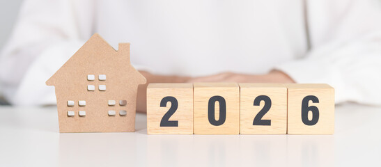 Happy New Year 2026 with house model. real estate, Home loan and mortgage, tax, investment, financial, savings and New Year Resolution concepts