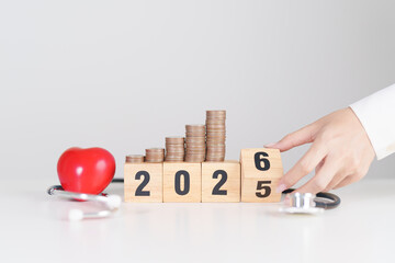 Happy New Year 2026 with doctor Stethoscope, coins stack and red heart on table. health care, Money saving, Goal, Resolution, health Insurance, Wellness and medical concept