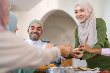 Muslim big family sharing traditional meal together around dining table wearing hijabs and kufi in cultural love, ramadan iftar celebration, eid al-fitr festive, halal meal gathering food culture