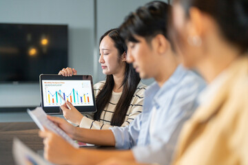 Asian businesswoman startup presenting data summary chart on tablet meeting with colleagues, financial report analysis teamwork strategy planning corporate success at office, marketing, data analytics