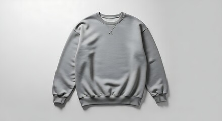 A plain grey crewneck sweatshirt lies flat against a white background, showcasing its simple and versatile design for everyday casual wear