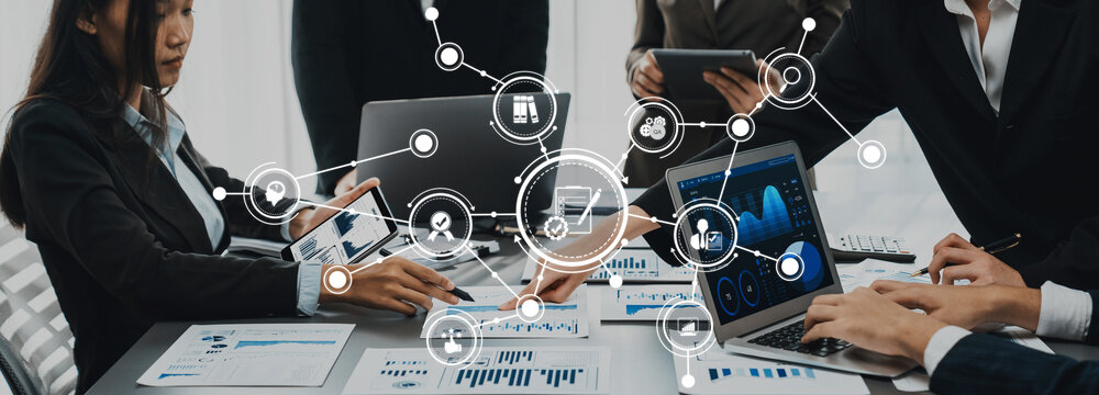 Panorama shot analyst team utilizing BI Fintech to analyze financial report with laptop. Businesspeople analyzing BI data dashboard displayed on laptop screen for business insight. Prodigy Amity