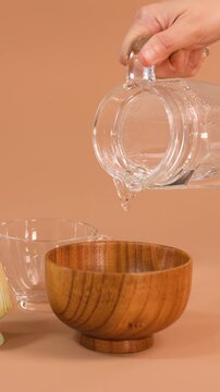 Pouring Hot Water Into Wooden Bowl for Tea Preparation