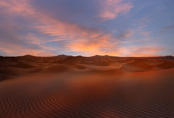 Naklejka premium Sand dunes in the Sahara Desert at amazing sunrise, Merzouga, Morocco - Orange dunes in the desert of Morocco - Sahara desert, Morocco