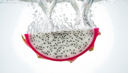 Fresh pink dragon fruit slice splashing into water isolated on white
