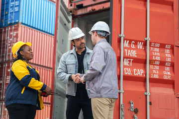 Logistics workers shaking hands and coordinating cargo tasks at container yard, Industrial warehouse staff team discussing freight operations and partnership near shipping container