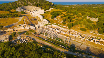 Gelemis, Turkey. Stone colonnaded street with columns and Agora square in Patara archaeological site, ancient urban architecture. Aerial View