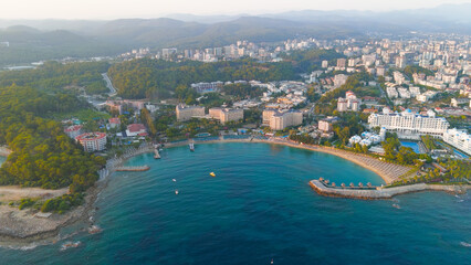 Avsallar, Alanya, Turkey. Evening panorama of a resort-lined bay with private beaches, city and mountain views.. Aerial View