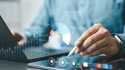 Close-up of a person analyzing digital charts on a tablet and laptop, representing business analytics, financial dashboards, investment insights, and data-driven economic growth.