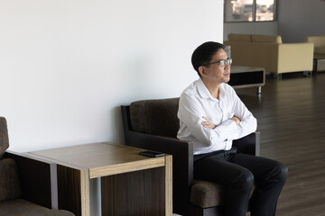 Asian businessman waiting for his colleague who is coming late and feeling bad about it