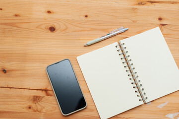 Creative workspace essentials notebook and phone wooden desk minimalist layout top view