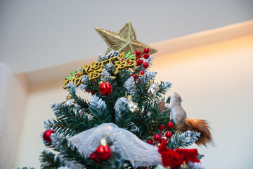 Decorating christmas tree with ornaments home interior festive scene cozy atmosphere close-up view