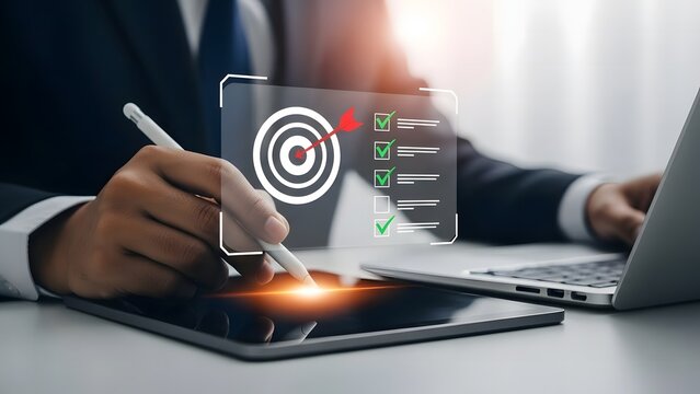 Businessman analyzing data on tablet with target graphic and laptop nearby