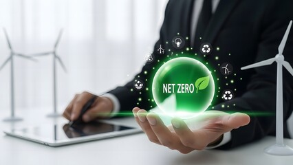 Businessman holding green energy hologram with wind turbines and tablet in background