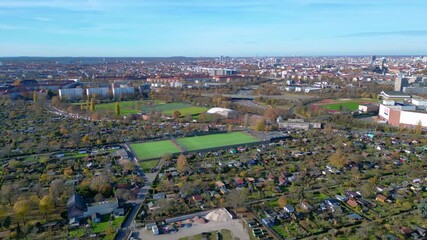 Berlin urban landscape with a large allotment garden area, sports soccer fields, football pitches and city infrastructure. Lovely aerial view flight panorama overview drone
