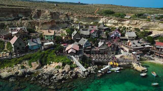 Aerial view of Popeye Village, Malta. Colorful seaside cottages, turquoise waters